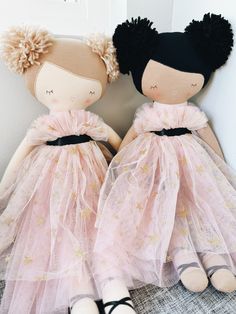 two dolls dressed in pink and black sitting next to each other