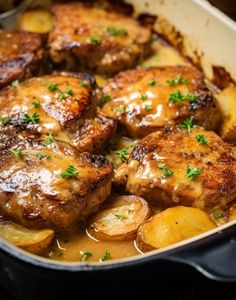 some meat and potatoes in a pan with gravy on the top is ready to be eaten