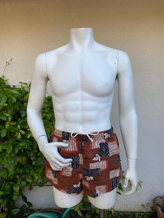 Vintage men's swim trunks in a great brown, orange and black print.  Small front pocket.  Elastic and drawstring waist.  Fabric feels like cotton barkcloth.  Great vintage condition.  Front right leg has what looks like a water mark and 3 tiny holes. label:  Catalina; Styled for the Stars of Hollywood fabric:  feels like cotton barkcloth size:  labeled size is 36.  Modern size is smaller.  Please check measurements for an accurate fit.  Questions are welcome! trunks were measured across the front side lying flat waist 14 1/2" - 17" rise 12 1/2" outer length 11 1/2" inseam 2" Fitted Swim Trunks With Pockets For Beach, Fitted Swim Trunks With Pockets For Vacation, Red Cotton Swim Trunks For Beach, Red Cotton Swim Trunks For The Beach, Summer Beachwear Bottoms In Brown, Cotton Swim Trunks With Drawstring For Vacation, Vacation Cotton Swim Trunks With Drawstring, Retro Bottoms With Pockets For Vacation, Retro Vacation Bottoms With Pockets