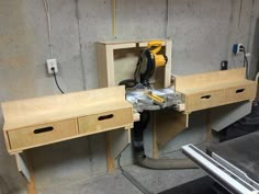 a workbench with two drawers and a power tool on it in the process of being built