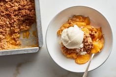 a white bowl filled with food next to a metal pan full of ice cream and peaches