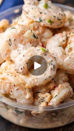 a glass bowl filled with shrimp salad on top of a table