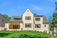 a large white house sitting on top of a lush green field