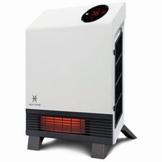 a white heater sitting on top of a wooden table next to a black and red clock