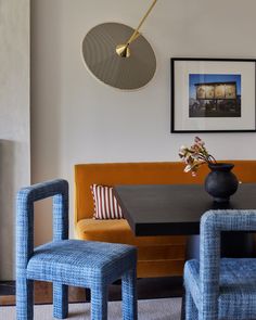 a living room with two chairs and a table in front of a fire place on the wall