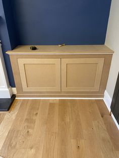 an empty room with blue walls and wooden flooring on the bottom half of it