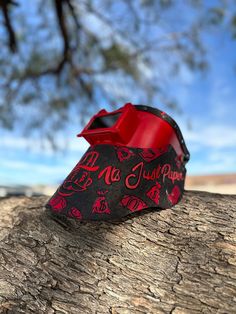 a piece of paper that has been wrapped in red and black on a tree branch