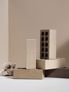 several cement blocks stacked on top of each other in front of a beige wall and white floor