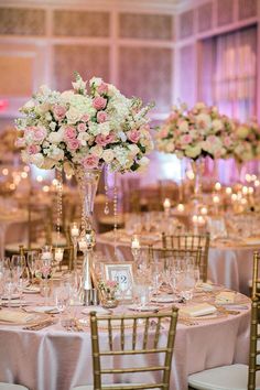 an elegant wedding reception with pink and white flowers in tall vases on the tables