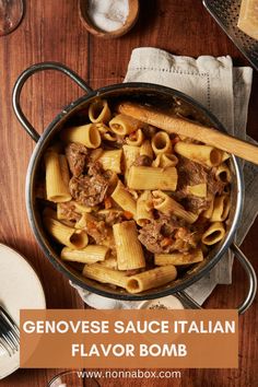 a pot filled with pasta and meat on top of a wooden table next to utensils