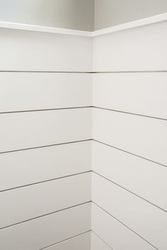 the corner of a bathroom with white painted walls