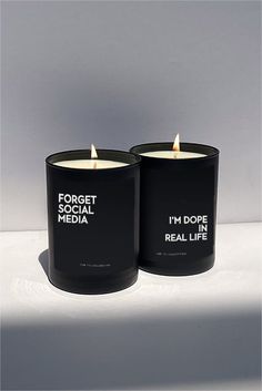 two black candles sitting next to each other on top of a white surface with the words i'm dope real life printed on them