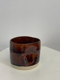 a brown vase sitting on top of a white table