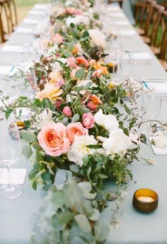 a long table with flowers and candles on it