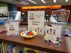 there are several boxes with candy in them on the table and bookshelves behind it