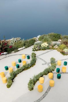 unique + colorful wedding setup in Santorini with stunning sea views, colorful stool guest seating, and a curvy aisle Santorini Wedding Decor, Santorini Wedding Decoration, Runway Ceremony Seating, Fairytale Princess Wedding Dresses, Santorini Wedding Chandelier, Santorini Greece Wedding Photography, Gray Color Palette, Wedding Setup, White Wedding Decorations