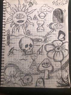 a notebook with some drawings on it and a skull in the middle is sitting on a table