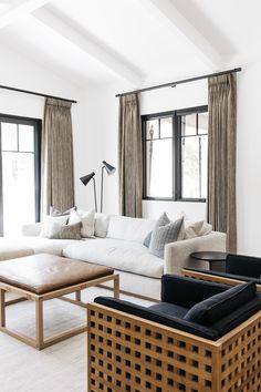 a living room filled with furniture and large windows