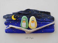 two penguins sitting on a branch in front of a night sky