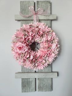 a pink wreath hanging on the side of a wall