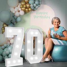 an older woman sitting on top of a blue ball with the number seventy in front of her