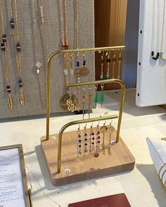 a display case with necklaces and jewelry on it's sides in a store