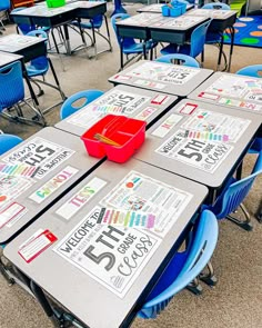 a classroom filled with desks and blue chairs