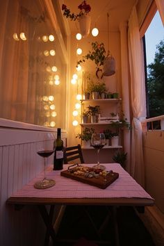 a table with a bottle of wine on it and some lights hanging from the ceiling