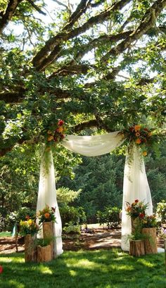 an outdoor ceremony with white drapes and flowers