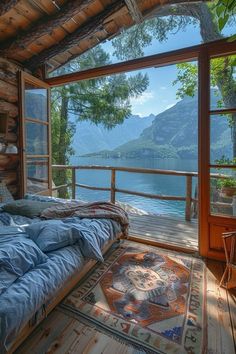 a bed sitting under a window on top of a wooden floor next to a lake