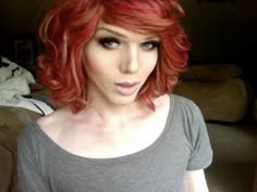 a woman with red hair is making a funny face