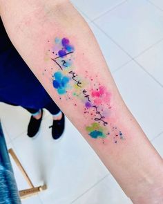 a person with a tattoo on their arm that says, i love you in watercolors