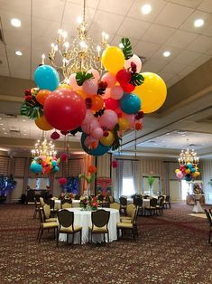 balloons are hanging from the ceiling above a banquet table