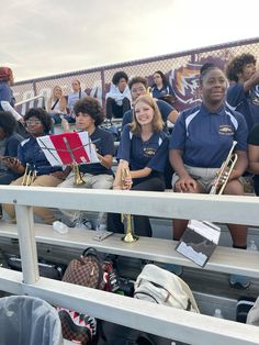 a group of people sitting on bleachers with musical instruments