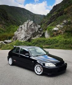 a black car parked in front of a mountain