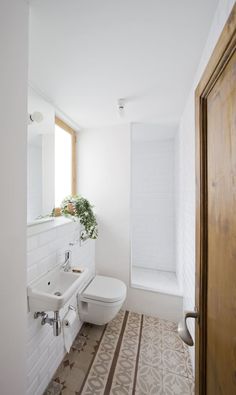 a bathroom with a sink, toilet and bathtub next to a wooden door in it