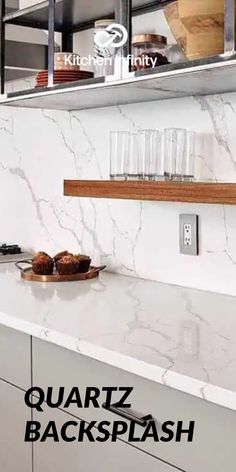 a kitchen with marble counter tops and white cabinets in the back drop area, along with glass shelving