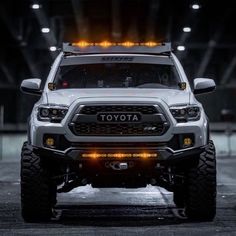 the front end of a white toyota truck with lights on it's bumpers