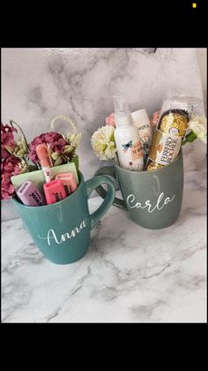 two mugs filled with personalized items on a marble counter top next to each other