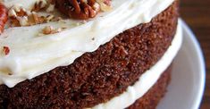 a cake with white frosting and pecans on top