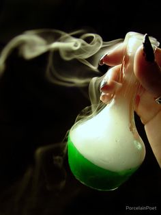 a hand holding a flask filled with liquid and steam rising from it's top