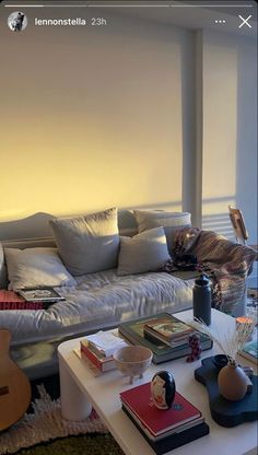 a living room filled with lots of furniture and books on top of a white coffee table