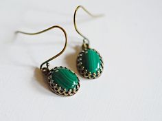 "Gorgeous artisan handcrafted natural stone tiny malachite earrings feature brilliantly polished cabochon emerald green malachite gemstones. Rich lush forest green, dark and light green hues display unique striped patterns. Each stone is extremely beautiful high quality Grade B. I carefully hand set each gemstone in high quality open back crown trim edged styled antiqued gold bezels made by JBB Findings. Dainty emerald green drops are shown in the photos dangling from high quality antique brass Emerald Cabochon Earrings For Gift, Emerald Cabochon Earrings As A Gift, Handmade Adjustable Dark Green Jewelry, Elegant Green Onyx Earrings For Gift, Handmade Green Agate Earrings, Handmade Green Malachite Jewelry, Green Onyx Jewelry With Matching Earrings, Oval Green Brass Jewelry, Elegant Green Agate Earrings