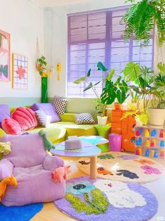 a living room filled with lots of colorful furniture and plants on top of the rugs