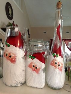 three glass bottles with santa claus on them