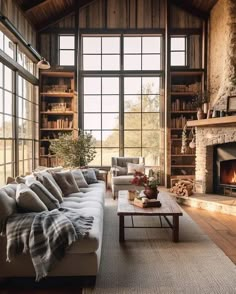 a living room filled with furniture and a fire place in front of a large window