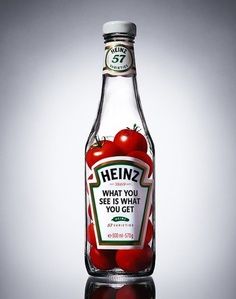 a bottle of heinz's what you see and eat olives on a reflective surface