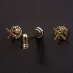 two metal knobs on the side of a black wall