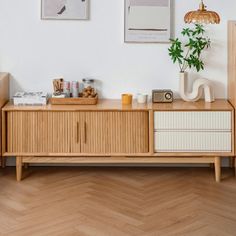 a living room with wooden furniture and pictures on the wall