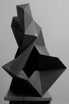 a black and white photo of a sculpture made out of folded paper on top of a table